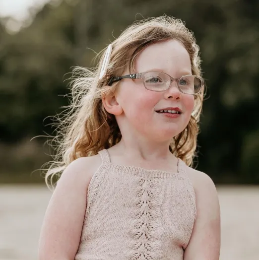 Child wearing glasses outdoors for vision correction treatment
