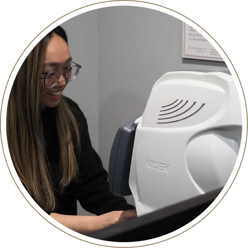 Optometry staff member operating diagnostic imaging equipment