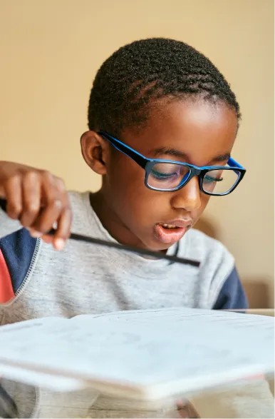 Child wearing glasses focusing while completing visual task